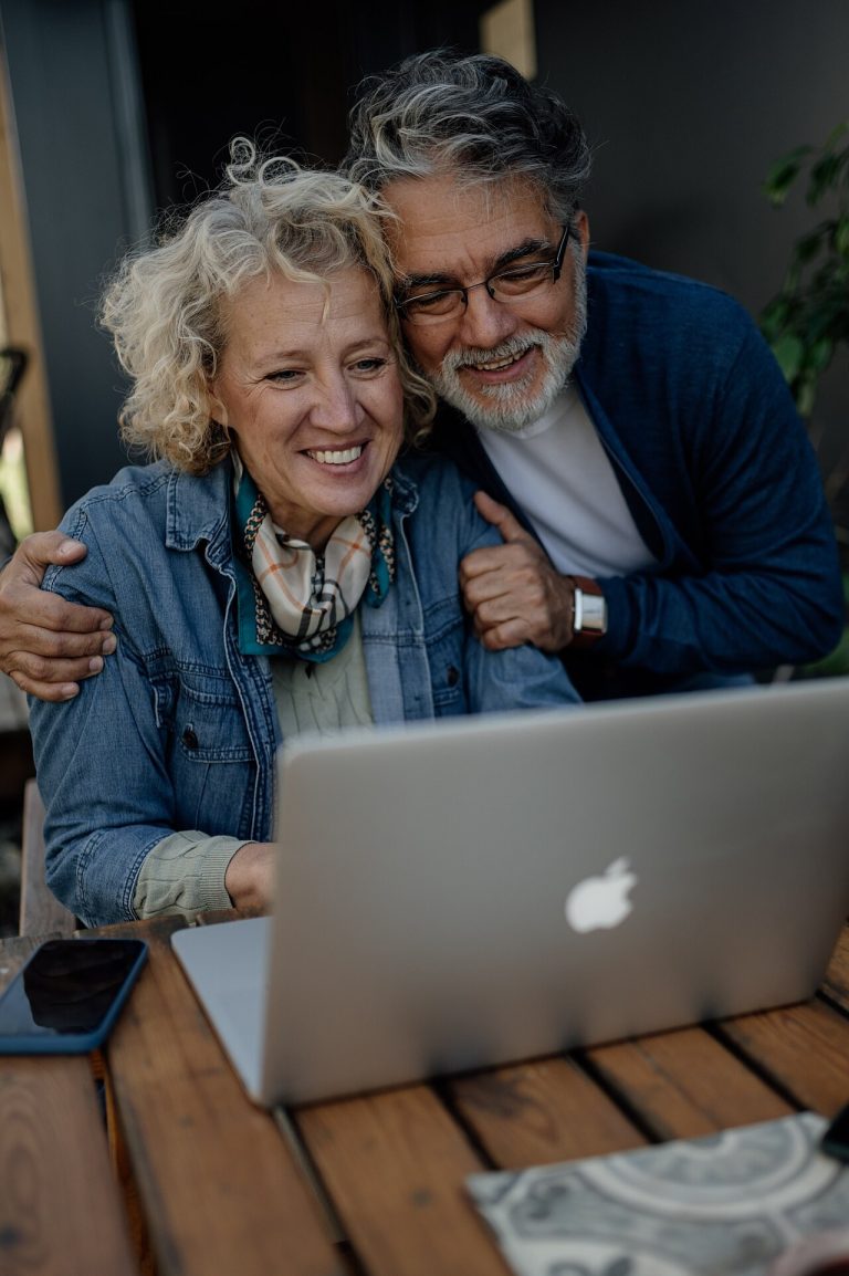 5 Smart Financial Moves to Consider in Your 60s Senior couple smiling while using a laptop together at home